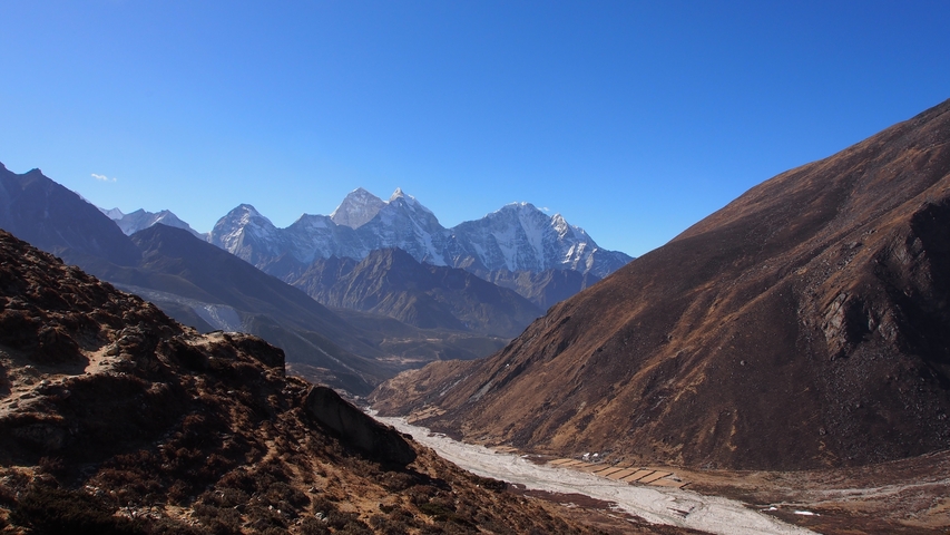       A vast valley with majestic mountain ranges in the background.
  