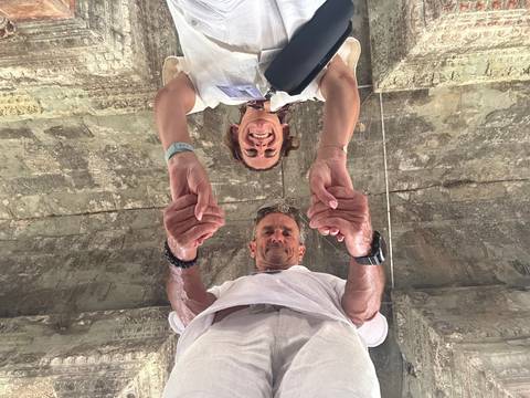 Unconventional viewpoint of people holding hands under a structure.