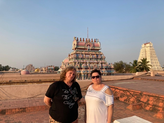       Two women posing in front of a colorful temple.
  