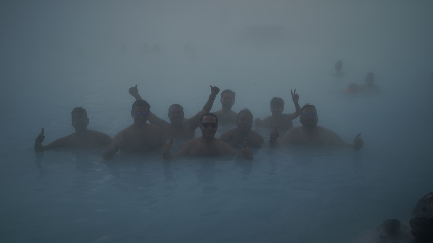 People enjoying a dip in a steaming hot spring.