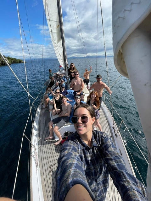 A group of friends enjoying a sailboat ride on a sunny day.