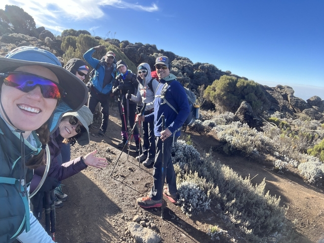 Group of trekkers posing on a mountain trail.