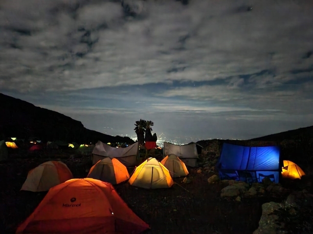 Night view of a campsite with illuminated tents.