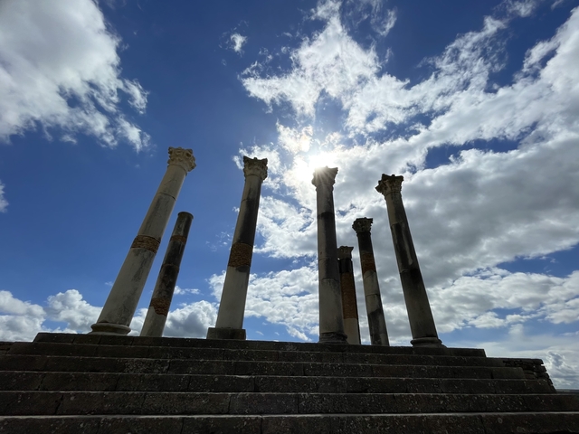 Ancient columns silhouetted against a bright sky.