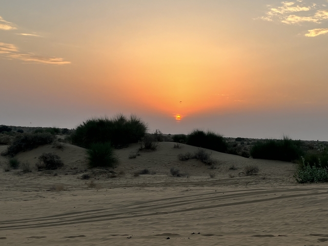 Sunset over desert dunes.