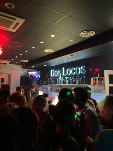 Crowded nightclub with neon signage.