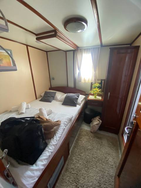 Interior of a cozy cabin with a bed and small window.