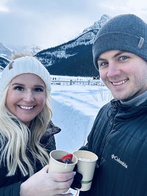       Smiling couple with snowy scenery.
  