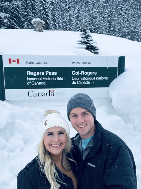       Couple posing in front of a national historic site sign.
  
