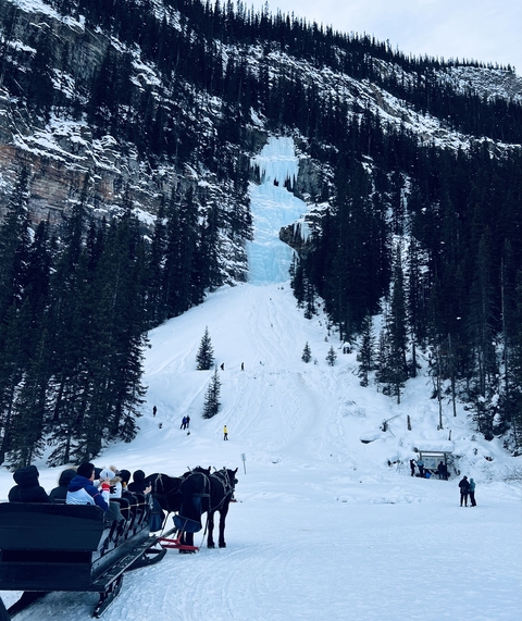       Snowy mountain trail with frozen waterfall.
  