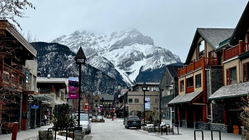       Charming town with a mountain backdrop and snow.
  