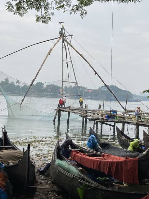 Traditional fishing technique with large nets, people in the background.