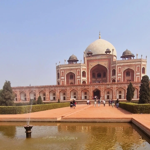 Humayun's Tomb with people walking in the garden.