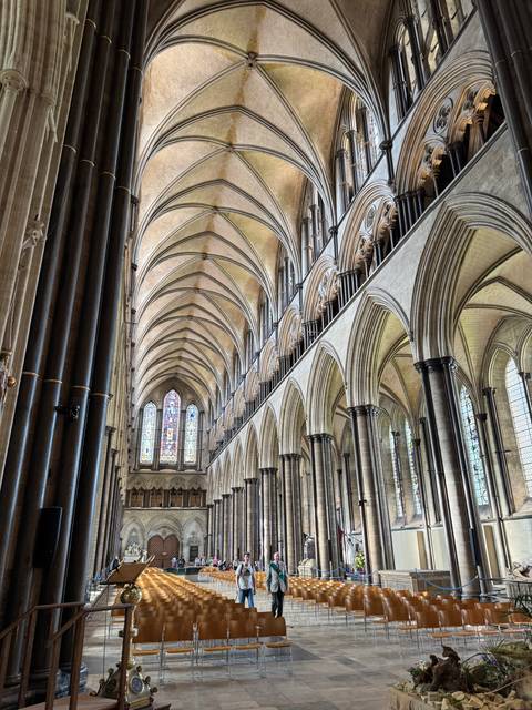 Interior of a cathedral with arched ceiling and stained glass.