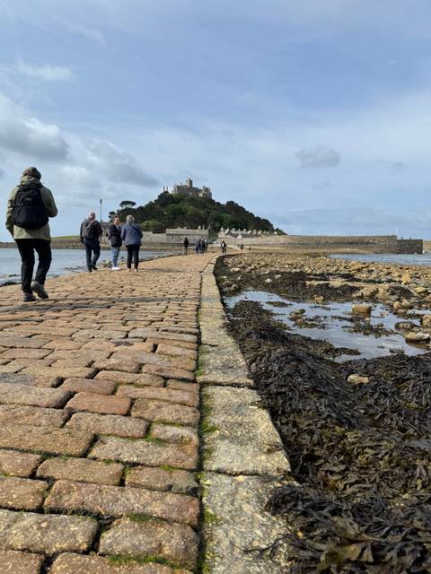 Stone pathway leading to an island with people walking.