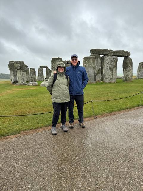 Two people posing in front of Stonehenge.