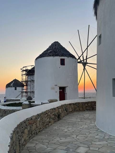 Traditional white windmill against a sunset sky.
