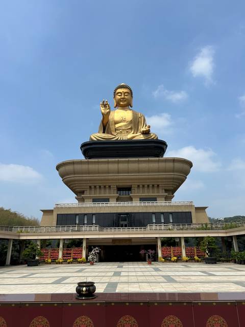 Large golden Buddha statue on temple grounds.