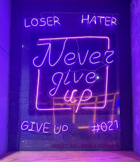 Neon sign displaying 'Never Give Up'.