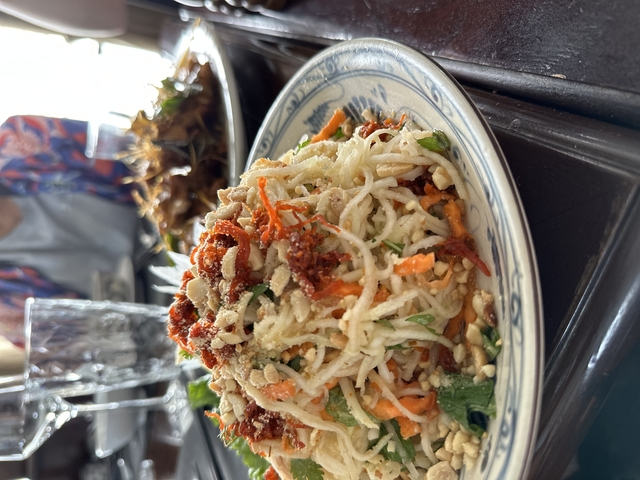 Bowl of food with shredded vegetables and toppings.