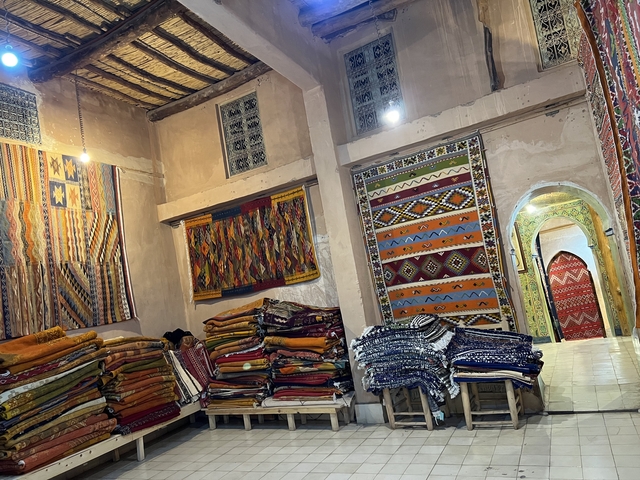 Interior of a shop filled with colorful textiles and rugs.