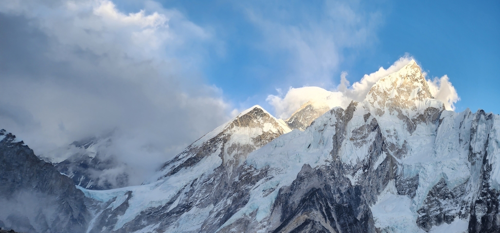       Snow-capped mountain peaks under a clear blue sky.
  