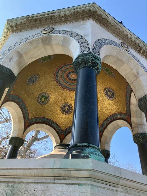       Ornate architectural feature with decorative golden and mosaic ceiling, supported by a large column.
  