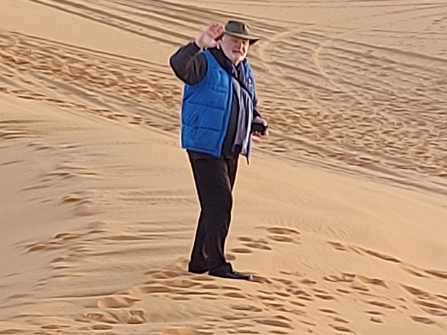 A person in the desert waving.