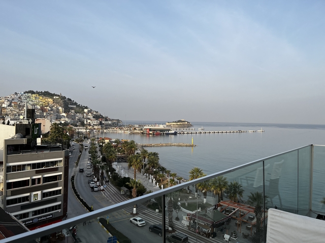 View of a coastal cityscape with buildings and a pier.