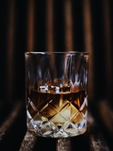 Close-up view of a glass of whiskey on a table.