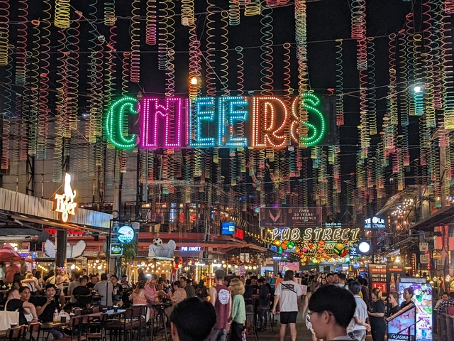       Vibrant night market with bright signs and crowds.
  