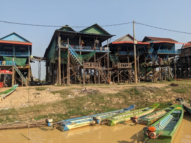       Stilted houses along a riverbank.
  