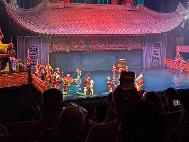       Water puppet show in a traditional stage setup.
  