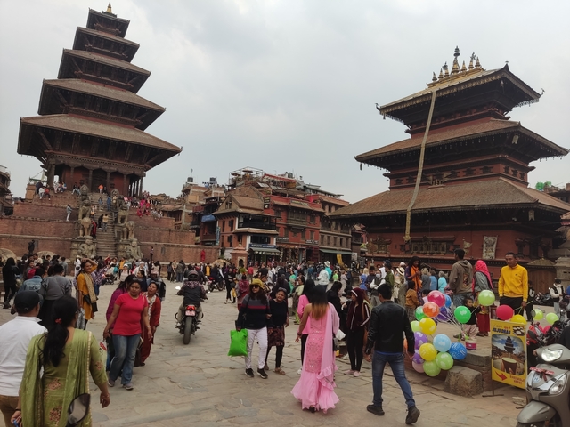       Crowded square with traditional buildings and visitors.
  