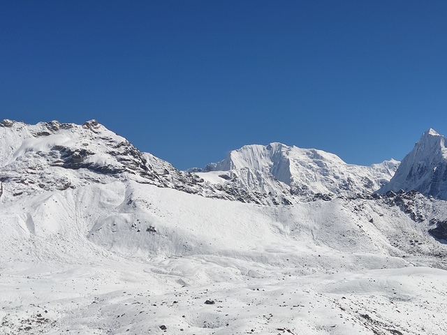       Snow-covered mountains under a clear blue sky.
  