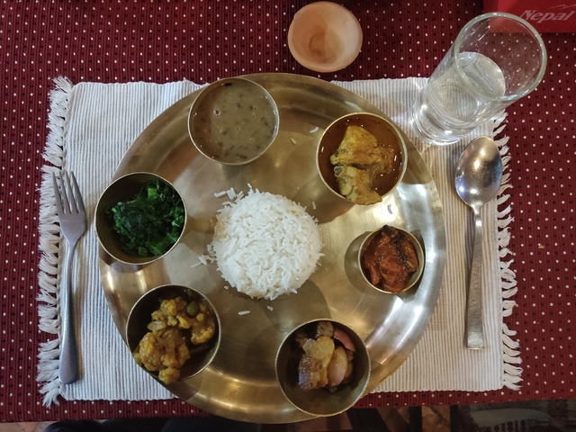       Traditional Nepalese thali meal with rice and various side dishes.
  