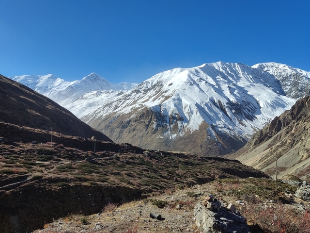       Wide vista of snow-covered mountains with a valley in the foreground.
  