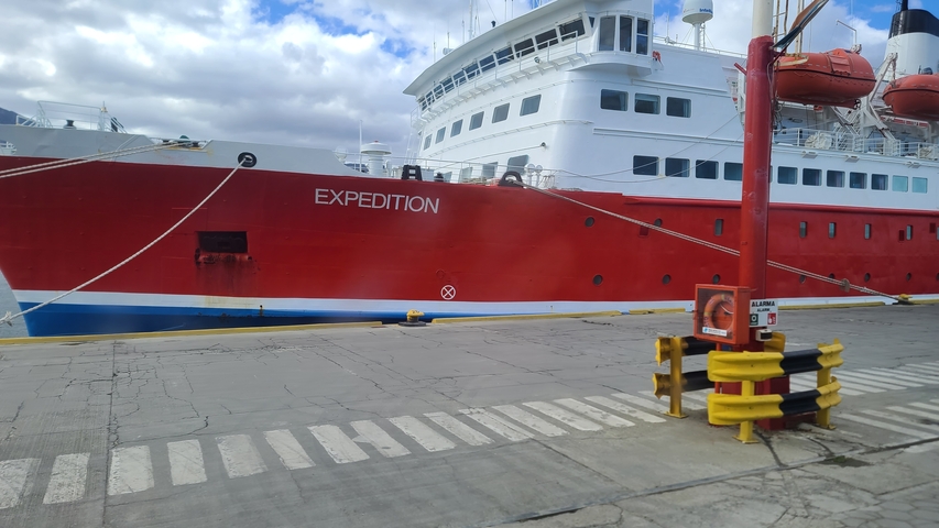 Expedition ship docked with cloudy sky.