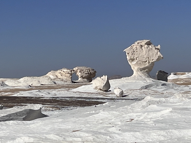 Rock formations in a desert landscape under a clear blue sky.
