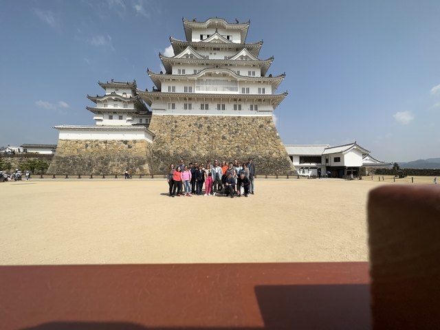 Group in front of a historical castle with clear sky.