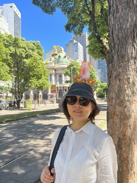 Woman in a hat near an ornate building.