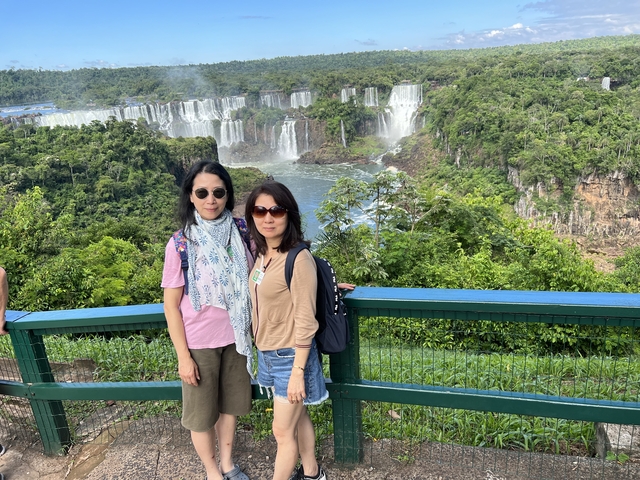       Two women posing in front of stunning waterfalls.
  