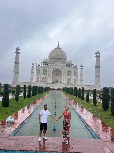 Couple posing together with the Taj Mahal as a backdrop.