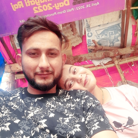       Couple smiling under a colorful canopy
  