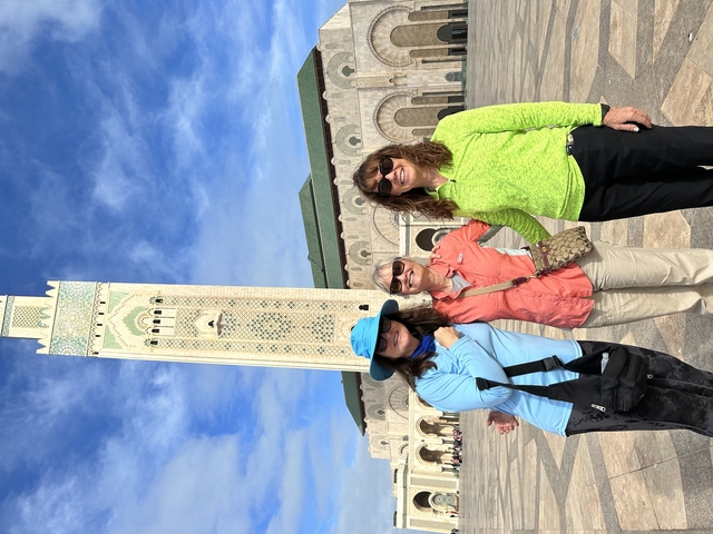 Three people in front of the Hassan II Mosque in Casablanca.