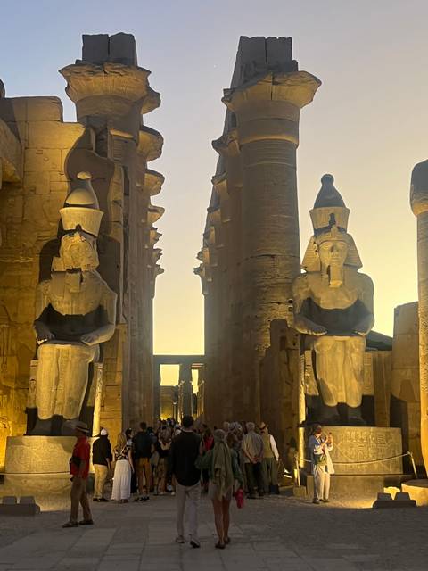       Visitors in front of an impressive ancient Egyptian temple.
  