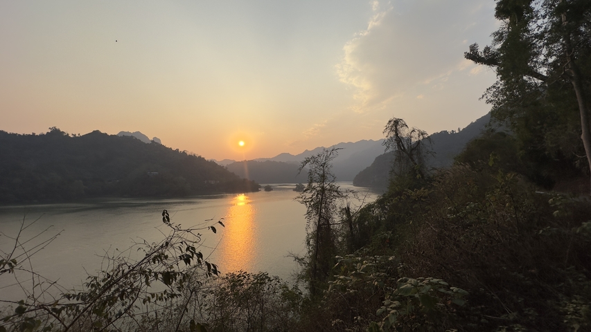       Sunset over a lake with mountains in the background.
  
