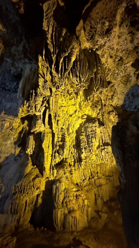       Stalactites and stalagmites inside a cave.
  