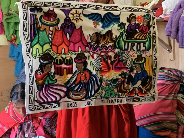       Colorful tapestry with people in traditional attire.
  