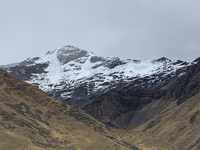       Snowy mountain peaks under a cloudy sky.
  